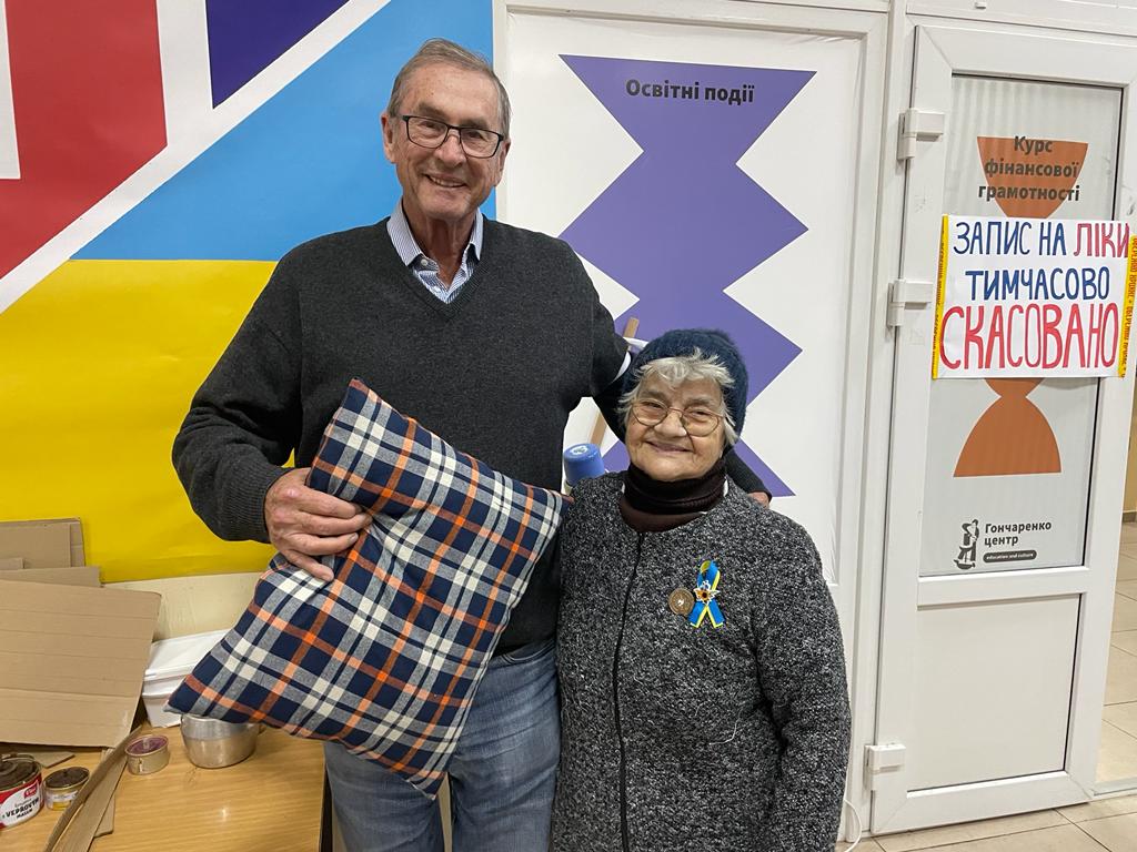 An 80-year-old volunteer presents Lord Ashcroft with one of the cushions she makes for frontline soldiers as a “thank you” for his support of Ukraine. Humanitarian centre, Odesa. (21/12/2022) 